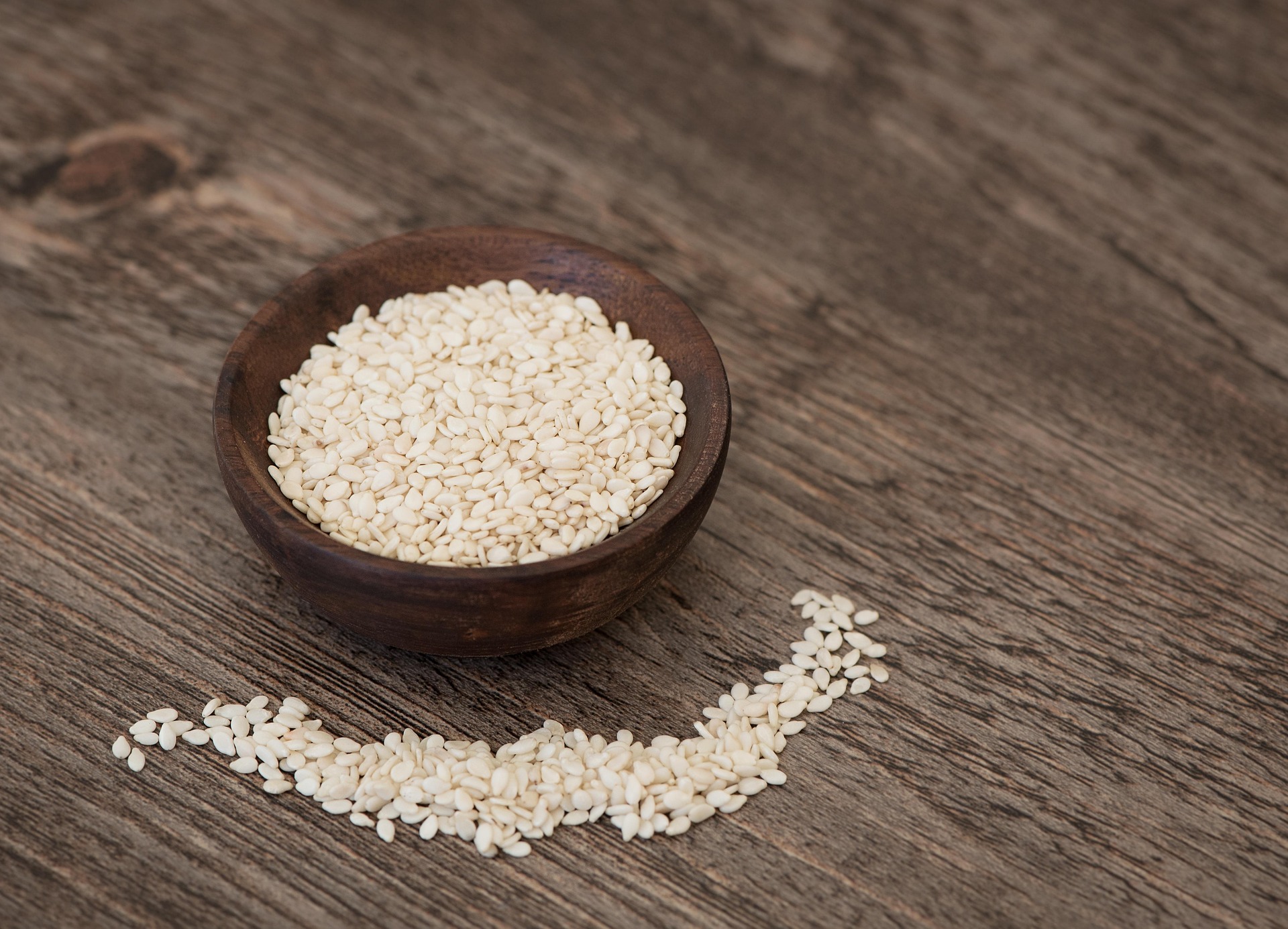 Hulled sesame seeds in a wooden bowl